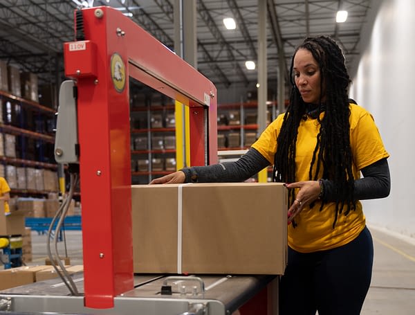 A woman finishing a pick and pack job.